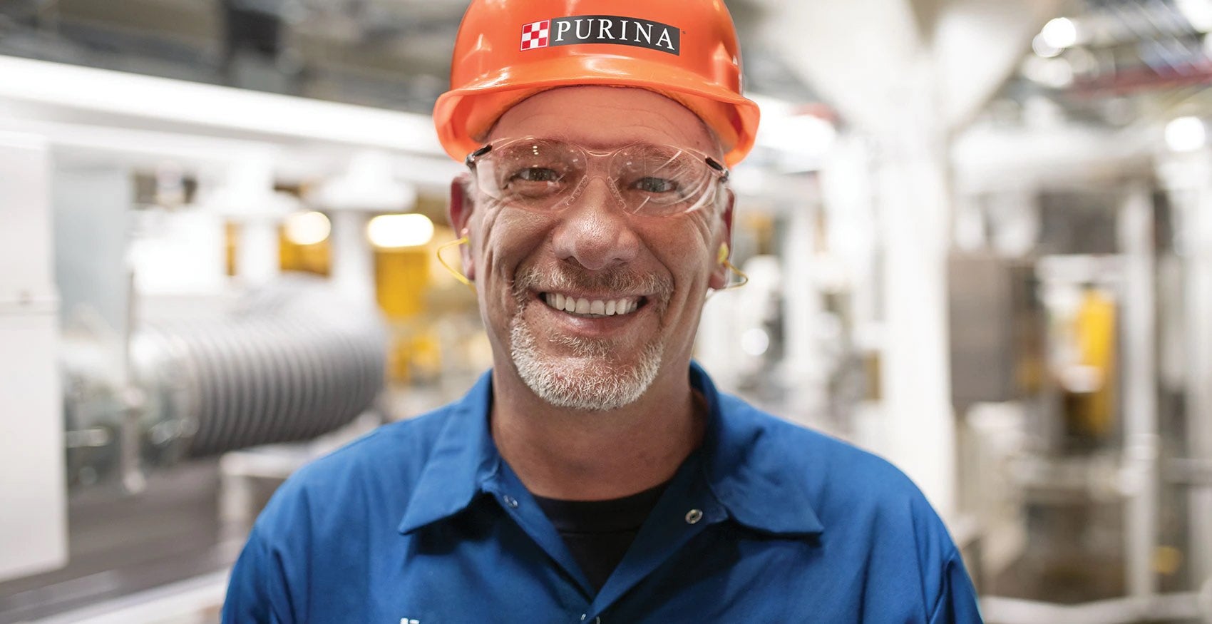 Headshot of Purina factory worker wearing an orange hard hat