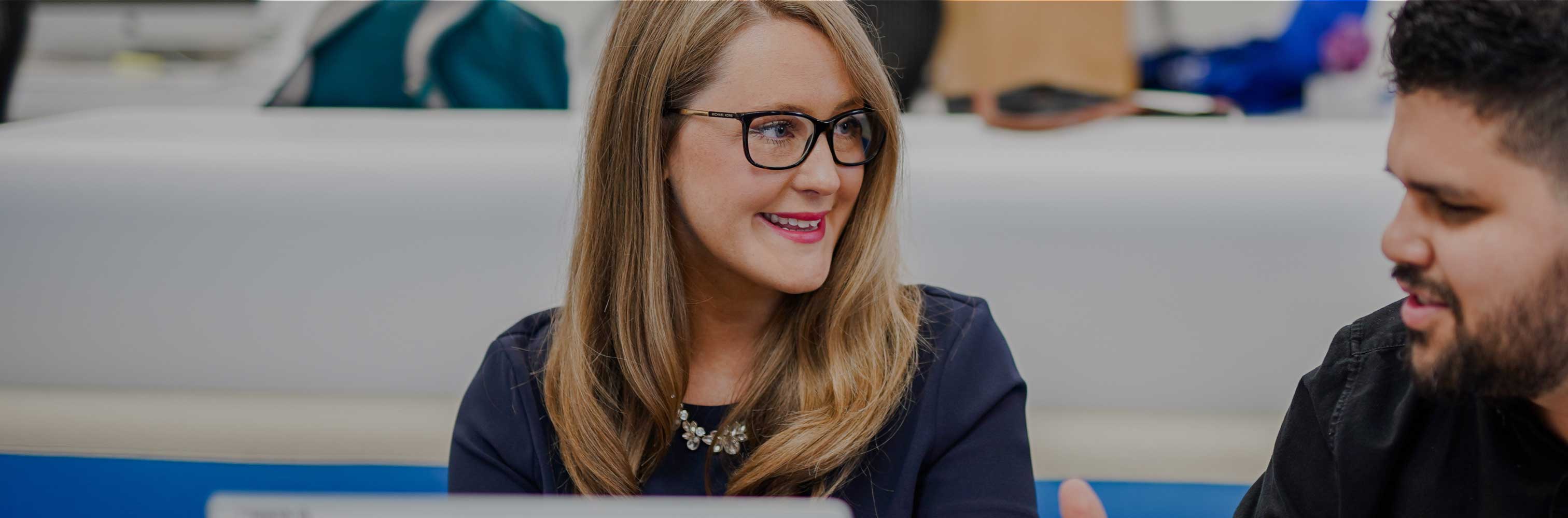 professional woman in glasses smiling during a meeting