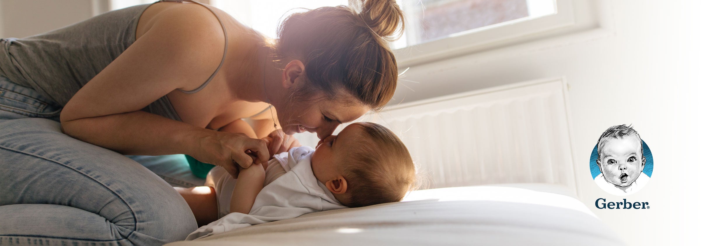 Mom snuggling with her baby on a bed