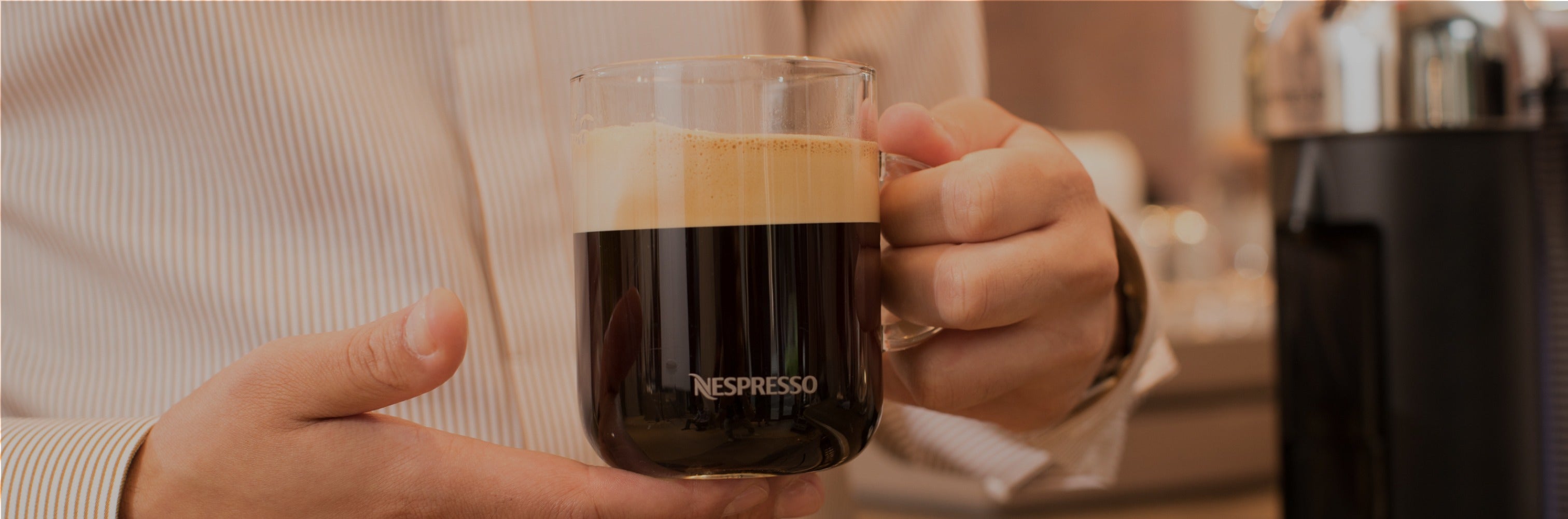 hands holding Nespresso mug with coffee