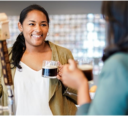 Two women drinking Nespresso