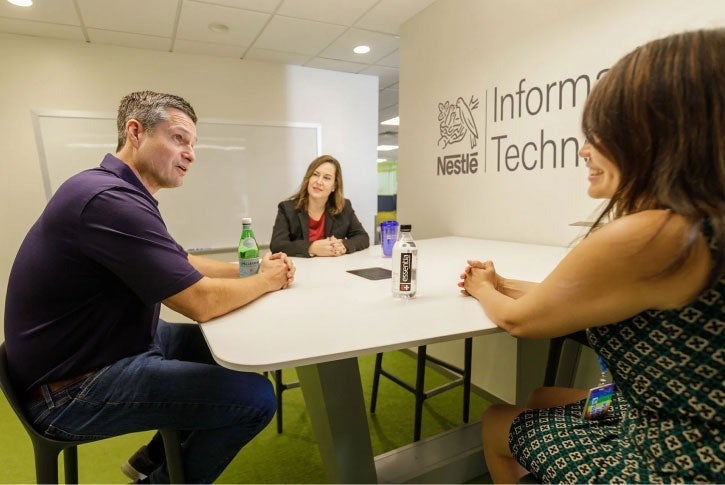 3 employees at a round table meeting