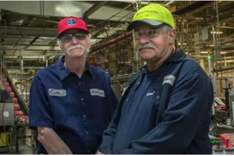 Two retiring Purina workers standing in the factory