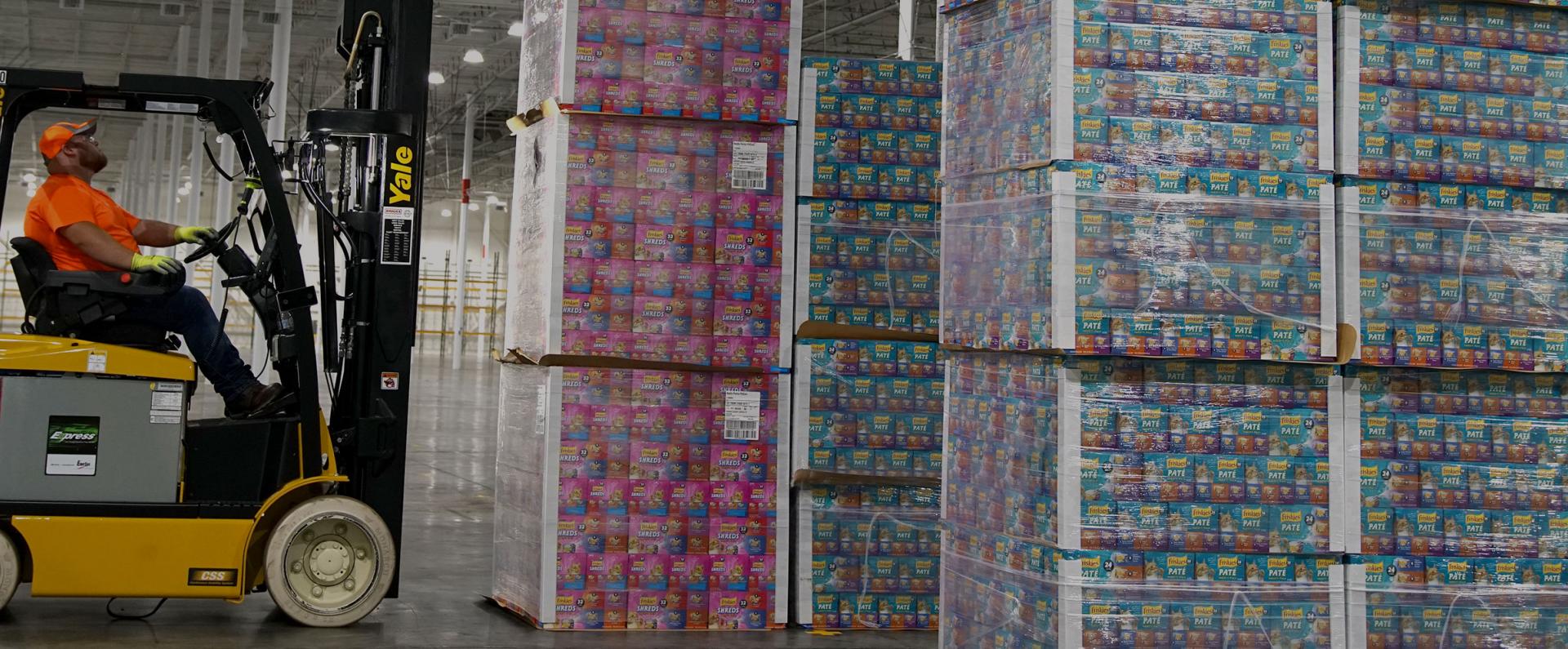 Forklift worker moving pallets of product in Purina factory in Hartwell